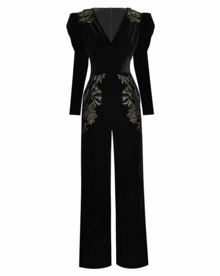 Combinaison pantalon noire coupe droite en velours avec manches longues et col en V. Il y a des broderies fleuries dorées sur le haut des épaules et sur les hanches .