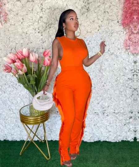Femme portant une combinaison orange à frange sur le côté.