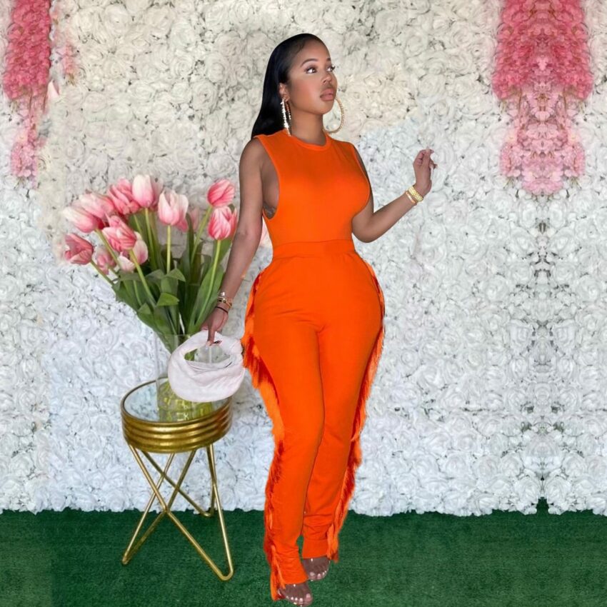 Femme portant une combinaison orange à frange sur le côté.