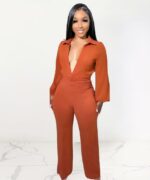 Femme portant une combinaison orange et fluide.