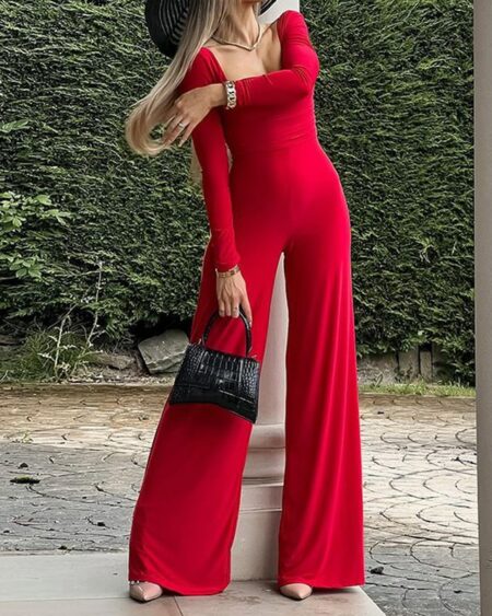 Combinaison pantalon rouge fluide pour femme avec des manches longues.