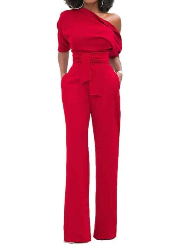 Combinaison pantalon habillée rouge pour femme avec buste asymétrique et ceinture nouée à la taille.