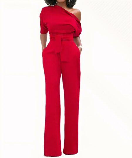 Combinaison pantalon habillée rouge pour femme avec buste asymétrique et ceinture nouée à la taille.