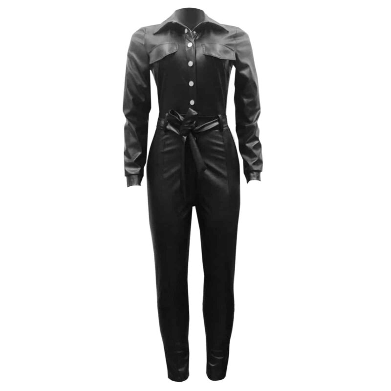Sur fond blanc, une combinaison pantalon noire à manches longues en simili cuir avec fermeture centrale par boutons pressions argentés et une ceinture à nouer à la taille.
