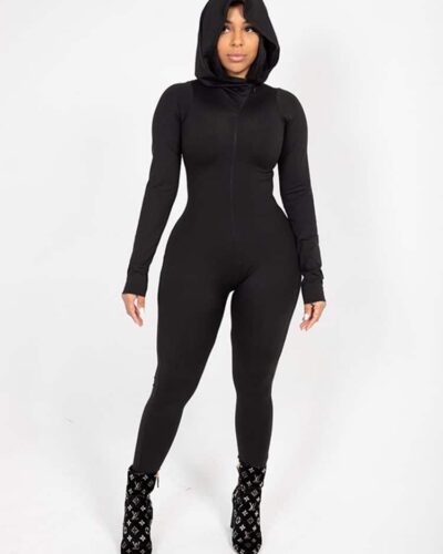 Combinaison intégrale noire zippée à capuche moulante pour femme.