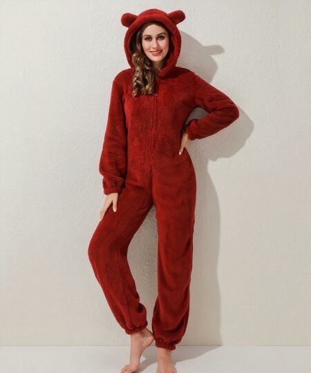 On voit une femme brune qui porte une combinaison rouge en pilou-pilou avec une capuche à oreilles.