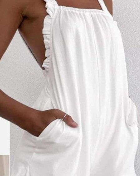 Femme avec une combinaison légère blanche se tenant debout sur fond blanc