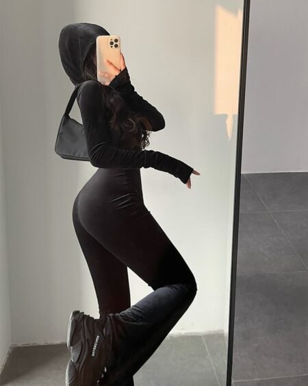 Femme portant une combinaison en velours noir à capuche.