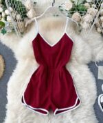 Combishort de sport pour femme rouge posée sur un tapis blanc.