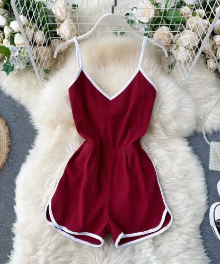 Combishort de sport pour femme rouge posée sur un tapis blanc.