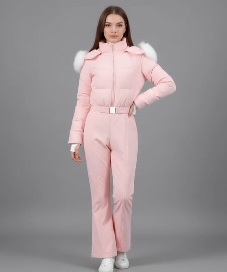 Combinaison de ski zippée et rembourrée à capuche rose portée par une femme brune sur fond gris.