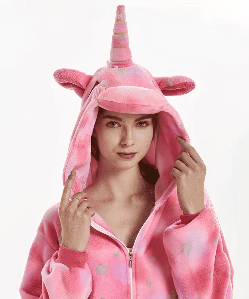 On voit une jeune femme blonde qui porte une capuche en polaire rose à l'effigie d'une licorne. La photo est prise sur fond blanc.