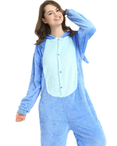 On voit une jeune femme assise sur le sol de son salon. Elle porte une combinaison de pyjama stitch.