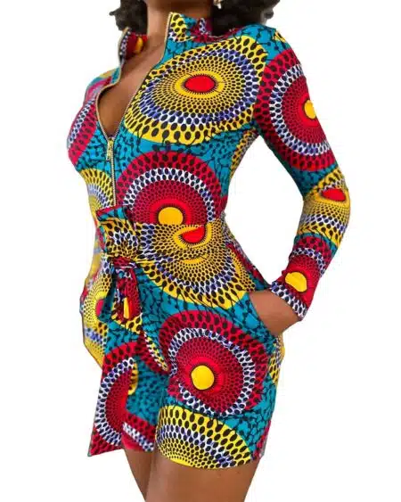 Combinaison short multicolore aux motifs ronds ethniques portée par une femme noire aux cheveux afro avec la main dans la poche.