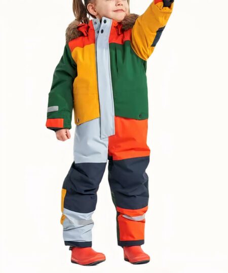 Combinaison de ski enfant colorée et imperméable pour fille et garçon portée par une petite fille sur fond gris
