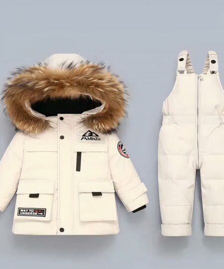 Combinaison de ski enfant avec une salopette à fermeture éclair sur fond gris