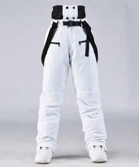Combinaison de ski femme avec pantalon à bretelles et imperméable sur fond gris