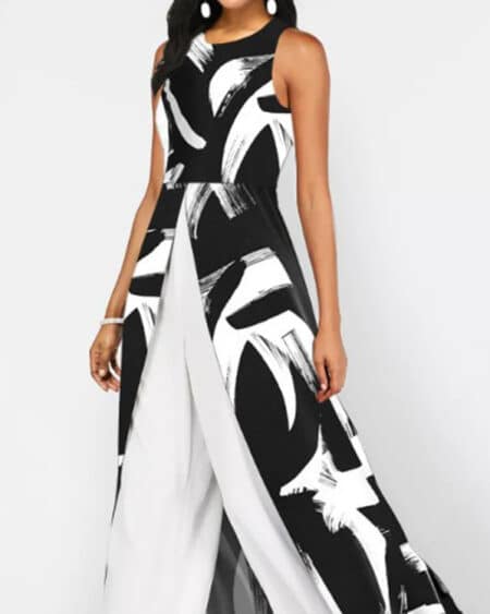 on voit une femme debout en combinaison noire et blanche à imprimé géométriques c'est une combinaison pantalon avec un voile sur l'arrière comme une jupe