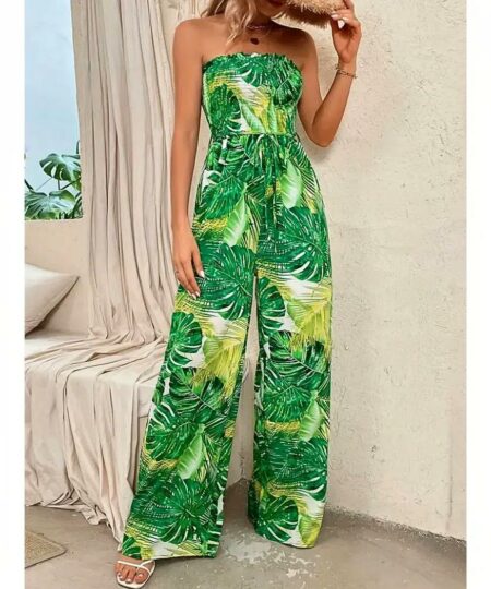 on voit une femme debout dans un salon clair, elle porte une combinaison à imprimé florale verte